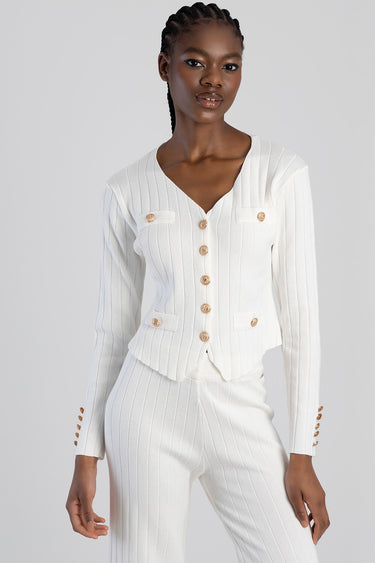 woman wearing white ribbed knit cardigan with gold buttons and matching knit trousers