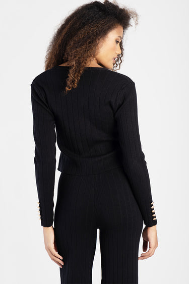 woman in black ribbed knit cardigan with matching pants, back view, gold cuff buttons, Blue Jean Traders