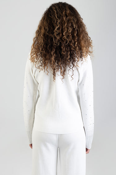 back view of a model in a white knit cardigan with pearl accents along the sleeves
