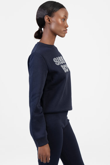 side profile of a woman wearing a navy blue sweatshirt with rhinestone lettering and matching jogger pants