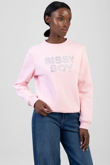 model wearing light pink crew neck sweatshirt with glittery lettering on the chest, paired with blue jeans