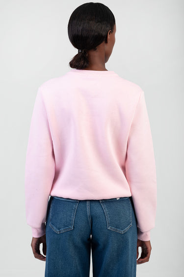 back view of a person in a light pink sweatshirt with blue denim jeans