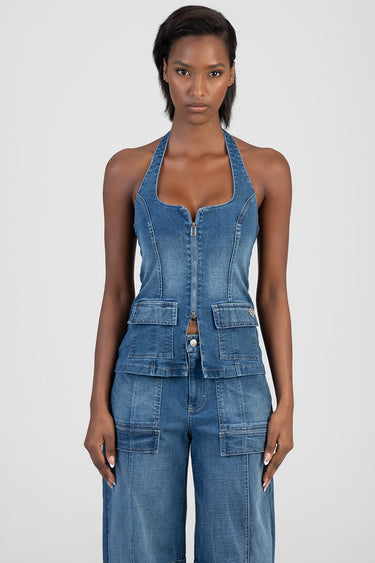 woman wearing blue denim halter top with front zip and large patch pockets paired with matching denim cargo pants