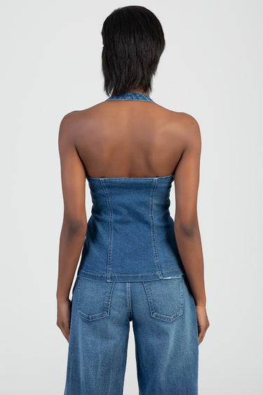 back view of a person wearing a blue denim halter top with an open back and matching denim jeans
