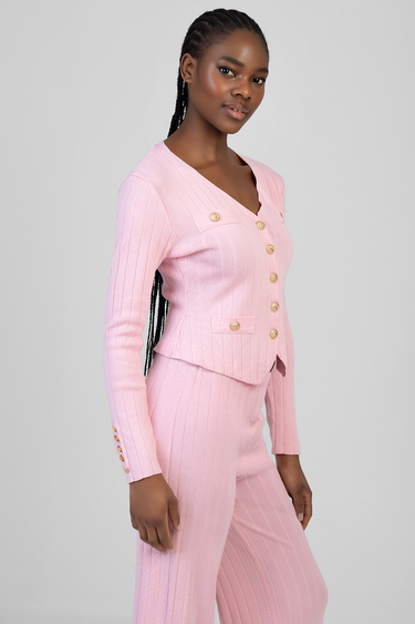 pink ribbed knit cardigan with gold buttons and matching pants on a model
