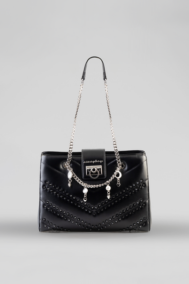 black quilted handbag with studded chevron pattern, silver chain straps, and metallic front clasp.