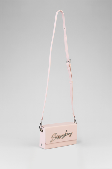 pink crossbody bag with a long adjustable strap and a silver script logo on the front