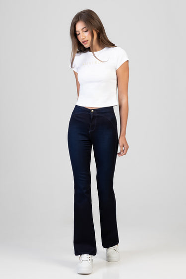 woman model in white cropped t shirt and dark indigo bootcut jeans with white sneakers