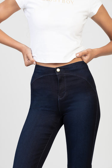 woman wearing dark indigo high waist jeans with gold button and white cropped t shirt