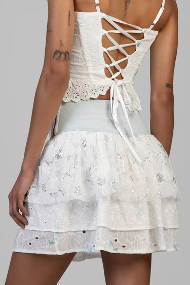 back view of a white lace up corset top with scalloped hem and a tiered eyelet skirt