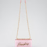 pink mini bag with a gold chain strap and pink leather top band, featuring a cursive logo on the front