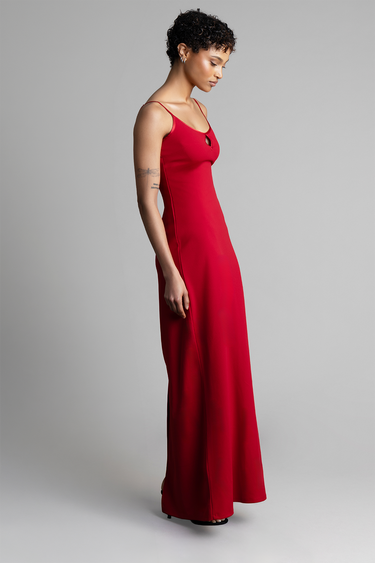 model in a red maxi dress with thin straps and a small neckline cutout, standing in profile.