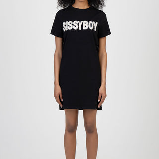 woman wearing a black short sleeve boxy dress with a white sequined logo across the chest knee length paired with black