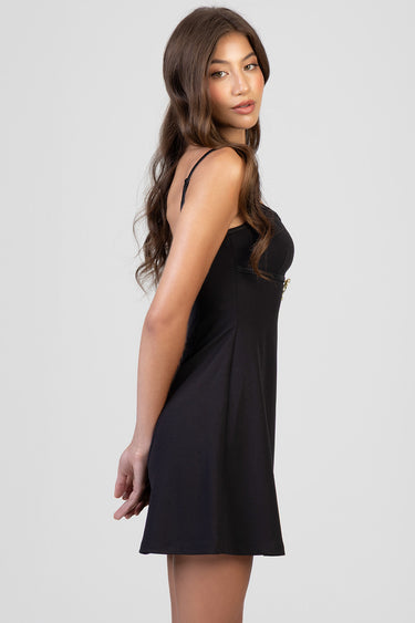 woman in a black mini dress with thin spaghetti straps, side profile view blue jean traders