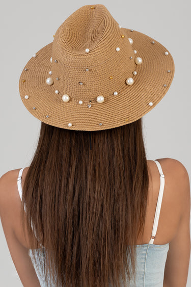 beige straw hat with pearls on the brim seen from the back on a model wearing a white strap top