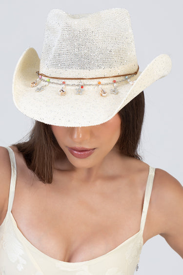 blue jean traders white straw western hat with a beaded chain and charms, worn by a woman in a cream lace top