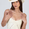 woman wearing a white straw western hat with a sequined band, cream lace dress, hands resting near shoulders