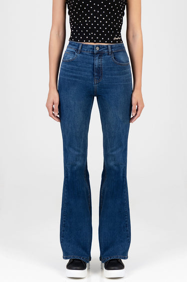 blue denim flare leg jeans with front pockets and contrast stitching on a model wearing a black polka dot top