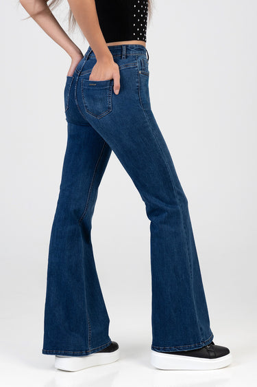 side view of blue denim flare leg jeans with back pockets and belt loops, paired with white platform sneakers