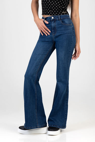 woman wearing blue flare leg jeans with a high waist and front pockets, paired with a black polka dot top