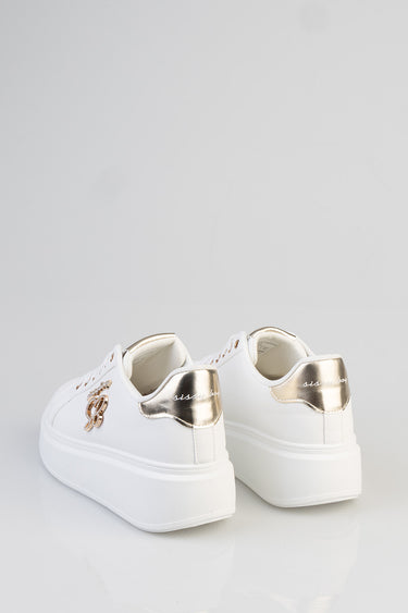 white platform sneakers with a gold metallic heel counter and a decorative emblem on the side