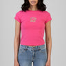 woman wearing bright pink short sleeve t shirt with a small sequin butterfly on the chest paired with faded blue denim jeans