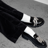 black patent loafers with crystal embellishments, paired with white ribbed socks and black trousers
