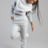 young woman in grey track pants and matching sweatshirt with iridescent butterfly details